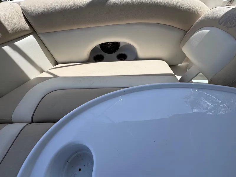 Slide: The Image of 2018 NauticStar DC 243 Sport Deck interior with beige seating and white table. - 30