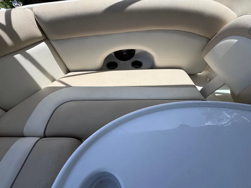 Slide: The Image of 2018 NauticStar DC 243 Sport Deck interior with beige seating and white table. - 31