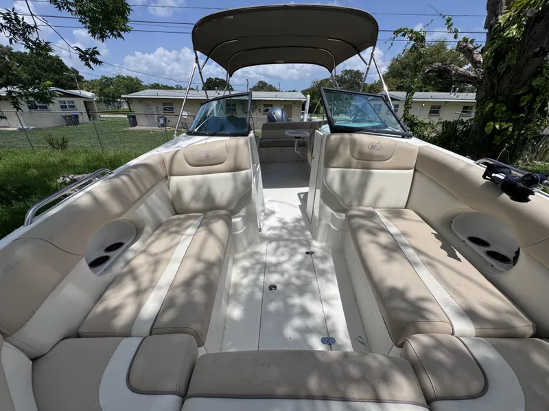 Slide: The Image of 2018 NauticStar DC 243 Sport Deck boat interior with beige seating and canopy. - 46