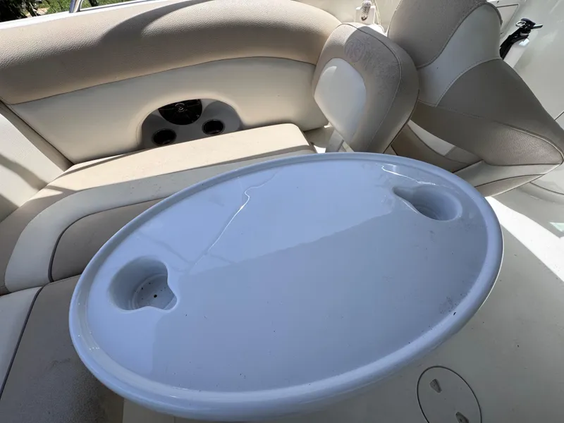 Slide: The Image of 2018 NauticStar DC 243 Sport Deck interior with oval table and cushioned seating. - 47