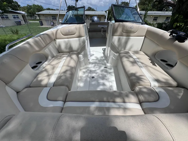 Slide: The Image of 2018 NauticStar DC 243 Sport Deck interior with beige seating and open layout. - 48