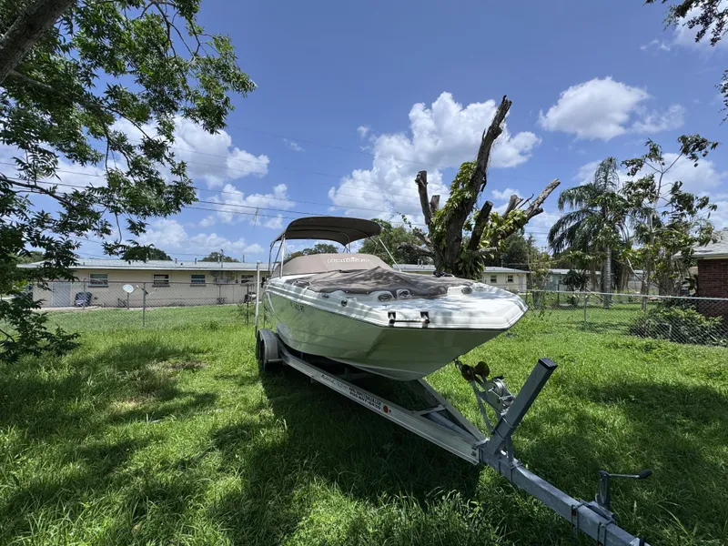 Slide: The Image of 2018 NauticStar DC 243 Sport Deck boat on trailer in grassy yard. - 50