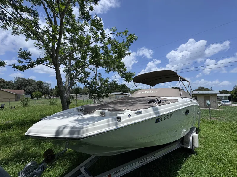 Slide: The Image of 2018 NauticStar DC 243 Sport Deck boat on trailer under clear blue sky. - 51