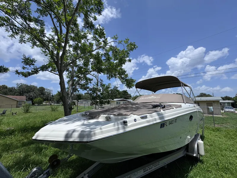 Slide: The Image of 2018 NauticStar DC 243 Sport Deck boat on trailer under clear blue sky. - 53
