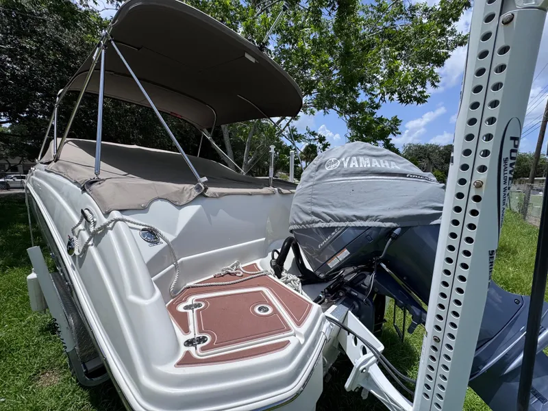 Slide: The Image of 2018 NauticStar DC 243 Sport Deck boat with Yamaha engine, parked on grass. - 54
