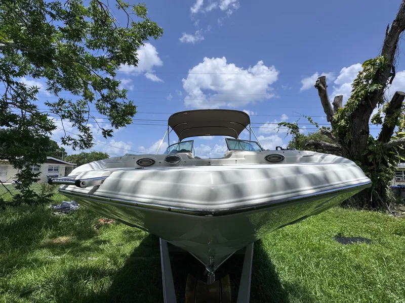 Slide: The Image of 2018 NauticStar DC 243 Sport Deck boat on grass under blue sky. - 8