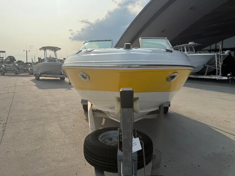 Slide: The Image of 2008 Chaparral SSi 190 boat with yellow hull on trailer, parked outdoors. - 10