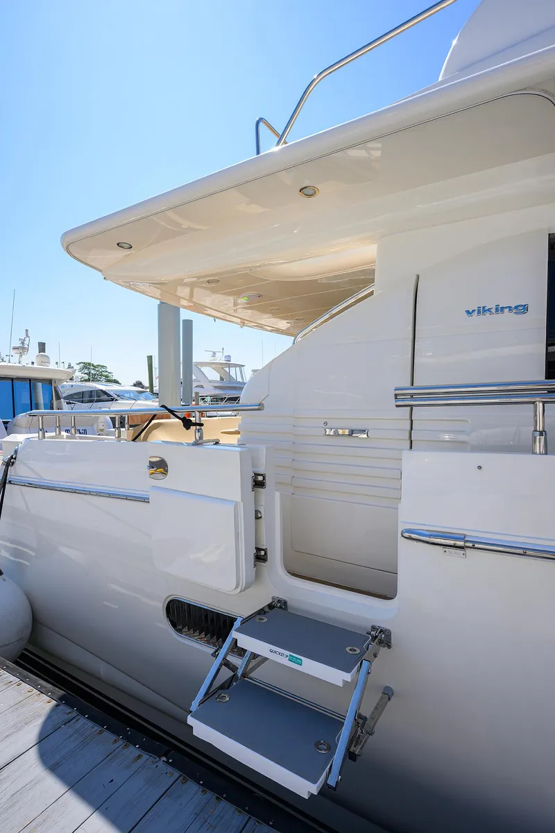 Slide: The Image of 2006 Viking Princess Sport Cruisers yacht with open boarding steps at dockside. - 2