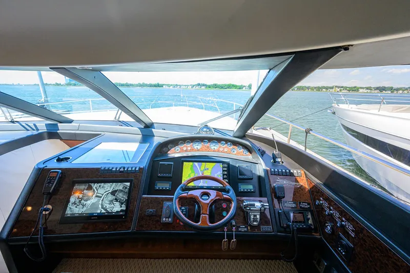 Slide: The Image of 2006 Viking Princess Sport Cruisers yacht cockpit with advanced navigation controls and scenic water view. - 23