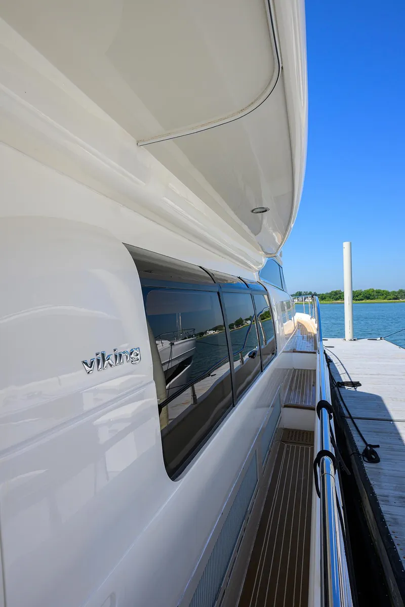 Slide: The Image of 2006 Viking Princess Sport Cruisers yacht docked by the water on a sunny day. - 8