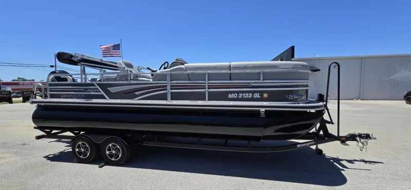 Slide: The Image of 2020 Ranger Reata 220FC pontoon boat on trailer, parked outdoors under clear blue sky. - 1