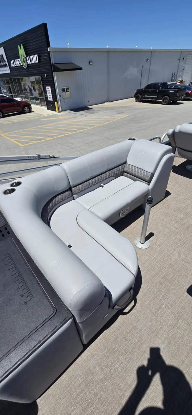 Slide: The Image of 2020 Ranger Reata 220FC pontoon boat with gray seating in a parking lot. - 14