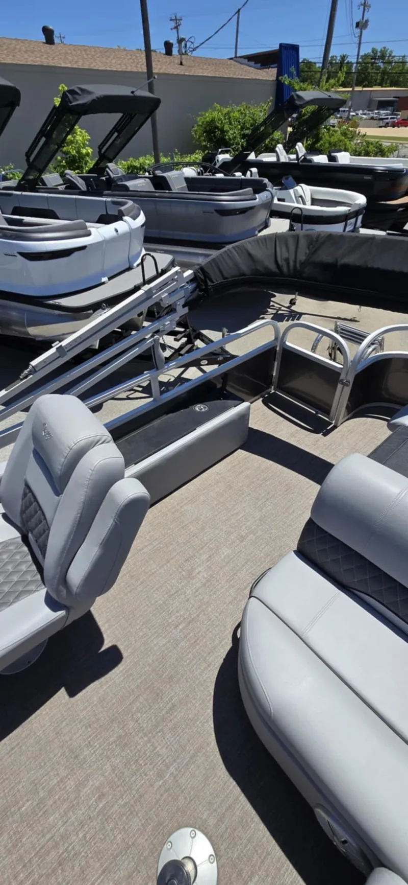 Slide: The Image of 2020 Ranger Reata 220FC pontoon boat with gray seating, displayed outdoors. - 5