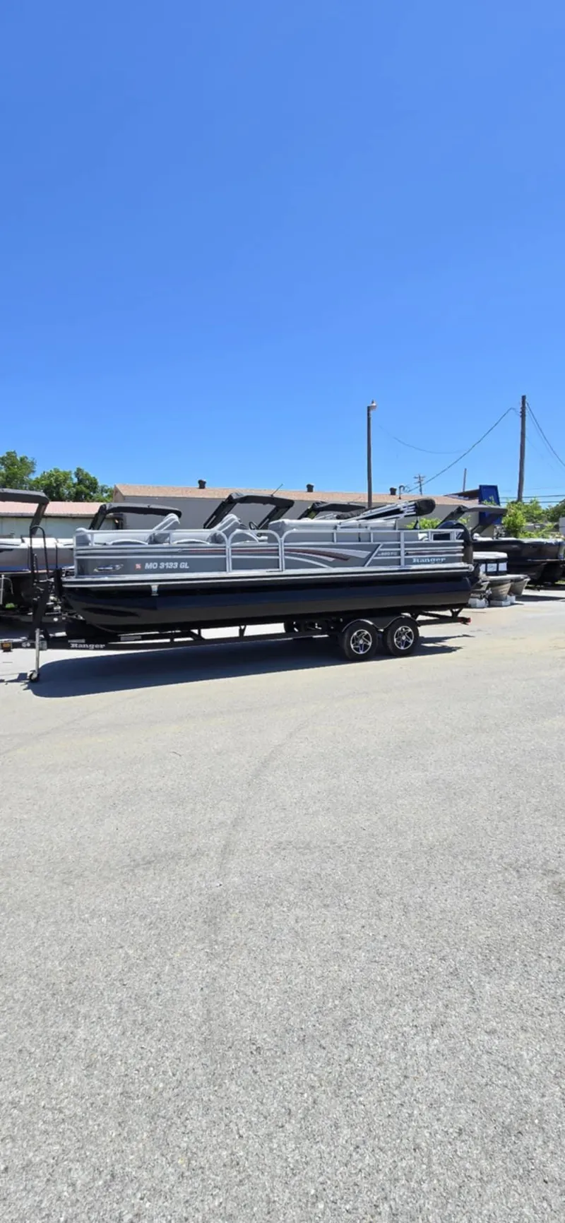 Slide: The Image of 2020 Ranger Reata 220FC pontoon boat on trailer under clear blue sky. - 6