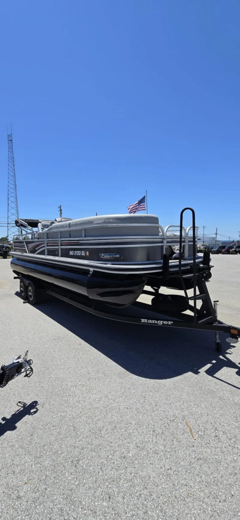 Slide: The Image of 2020 Ranger Reata 220FC pontoon boat on trailer, parked outdoors under clear blue sky. - 9
