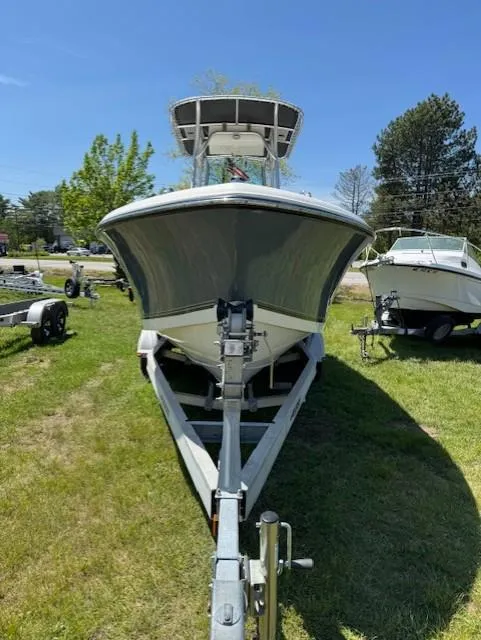 Slide: The Image of 2020 Mako 214 CC boat on trailer, parked on grass under clear blue sky. - 2