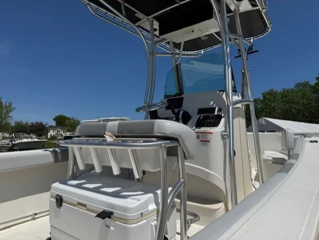 Slide: The Image of 2020 Mako 214 CC boat interior with seating and console under clear blue sky. - 4