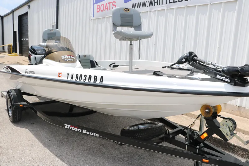 Slide: The Image of 2009 Triton 17 Explorer boat on trailer, parked outside a building. - 11