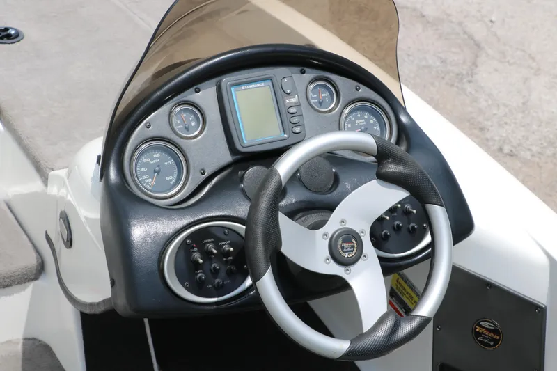Slide: The Image of Dashboard of 2009 Triton 17 Explorer boat with steering wheel and gauges. - 16