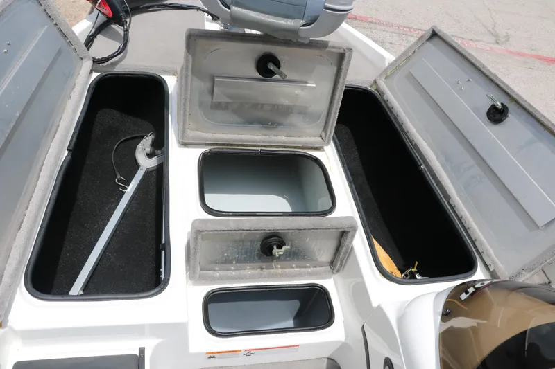 Slide: The Image of 2009 Triton 17 Explorer boat storage compartments with open lids and visible equipment. - 25