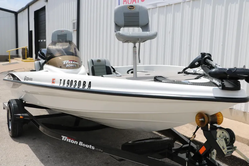 Slide: The Image of 2009 Triton 17 Explorer boat on trailer, parked outside a building. - 3