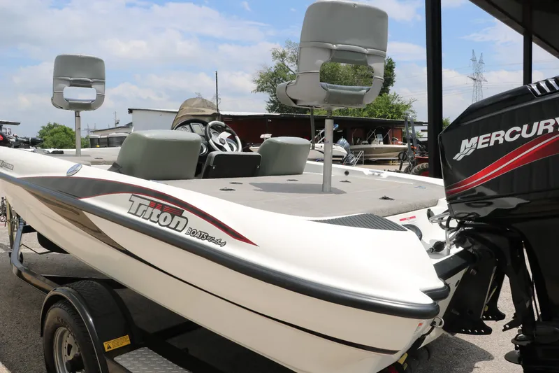 Slide: The Image of 2009 Triton 17 Explorer boat with Mercury engine, parked on trailer under blue sky. - 7
