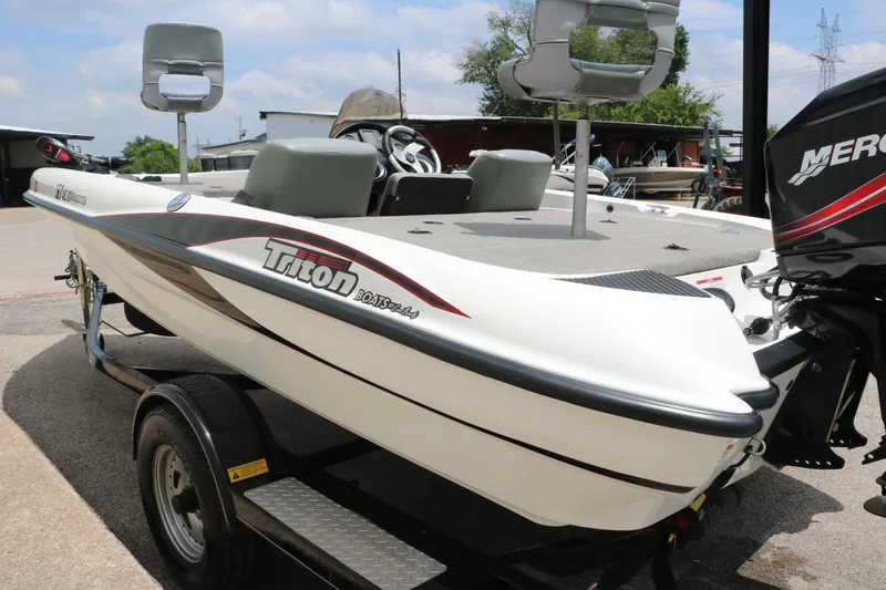 Slide: The Image of 2009 Triton 17 Explorer boat on trailer, featuring seating and Mercury outboard motor. - 8