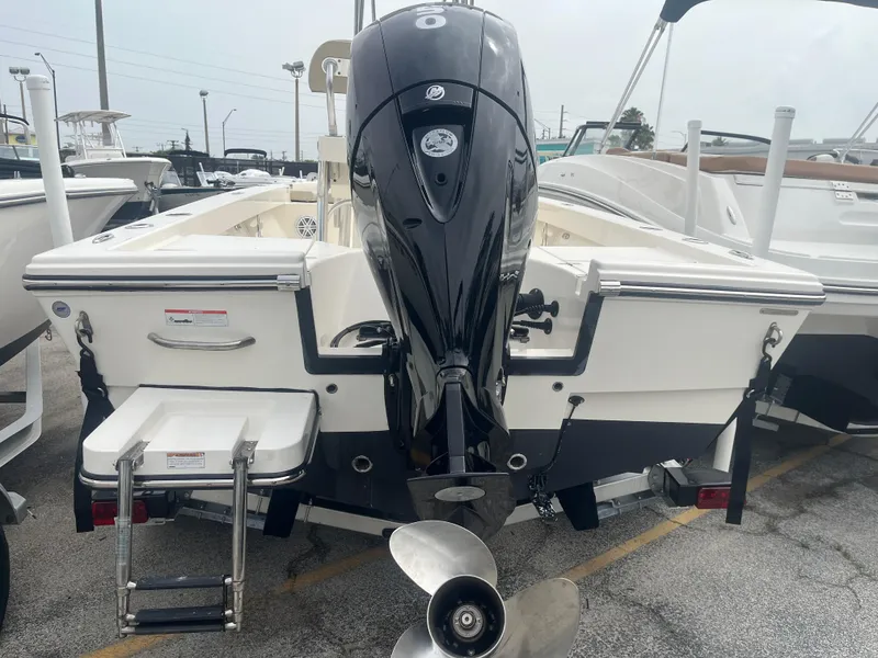 Slide: The Image of Pathfinder 2005 TRS boat, rear view with outboard motor and ladder, parked in marina. - 5