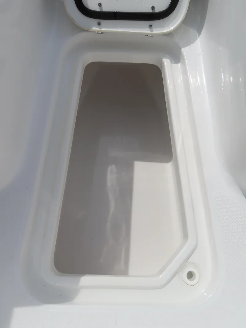 Slide: The Image of 2025 Sea Hunt Gamefish 25 storage compartment, white interior, open lid. - 11