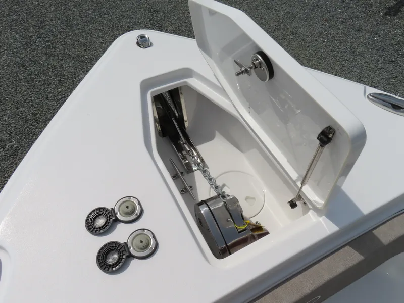 Slide: The Image of 2025 Sea Hunt Gamefish 25 anchor compartment with open hatch and chain mechanism. - 16