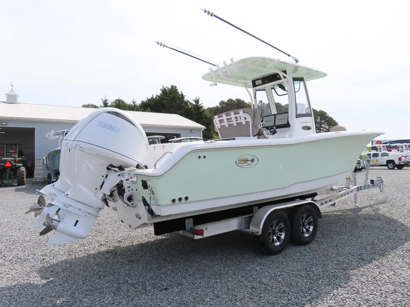Slide: The Image of 2025 Sea Hunt Gamefish 25 boat on trailer, featuring dual outboard engines. - 2