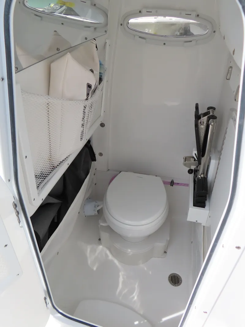 Slide: The Image of 2025 Sea Hunt Gamefish 25 boat interior with compact marine toilet and storage. - 21