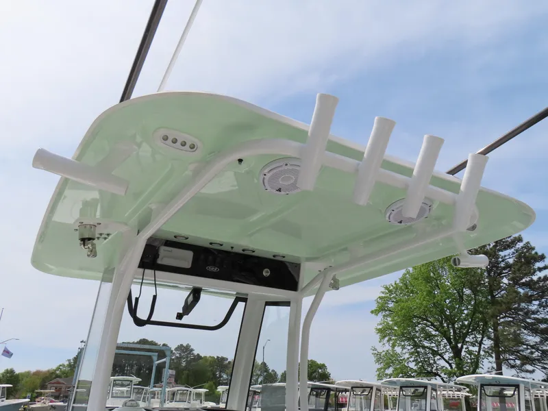 Slide: The Image of 2025 Sea Hunt Gamefish 25 T-top with rod holders and speakers, under a clear sky. - 28
