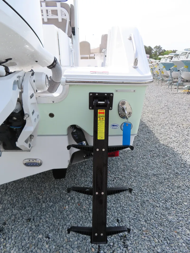 Slide: The Image of 2025 Sea Hunt Gamefish 25 boat with rear ladder on gravel surface. - 6