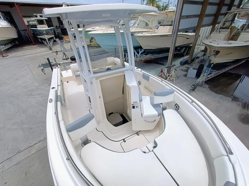 Slide: The Image of 2023 Robalo R222 Center Console boat in a marina, showcasing sleek design and spacious seating. - 10