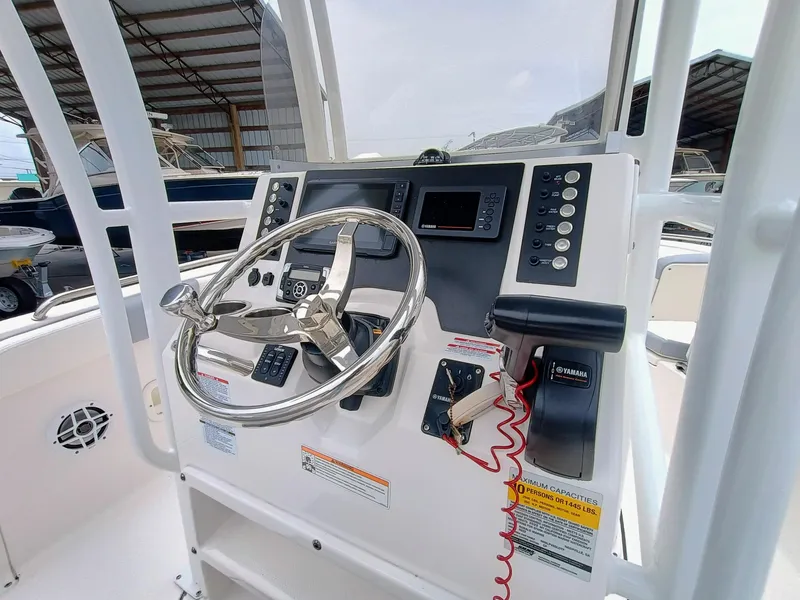 Slide: The Image of 2023 Robalo R222 Center Console boat dashboard with steering wheel and controls. - 18