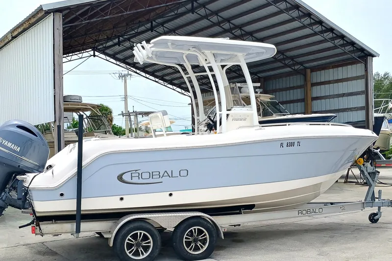 Slide: The Image of 2023 Robalo R222 Center Console boat on trailer in storage facility. - 2