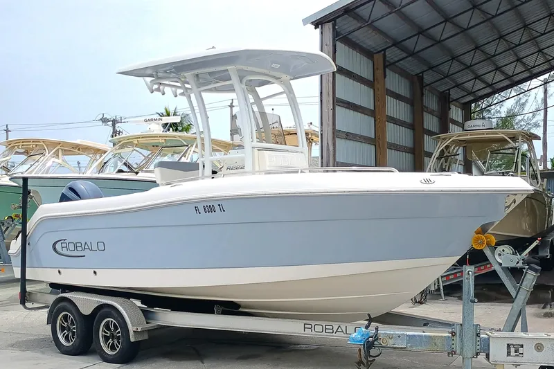 Slide: The Image of 2023 Robalo R222 Center Console boat on trailer in marina setting. - 3