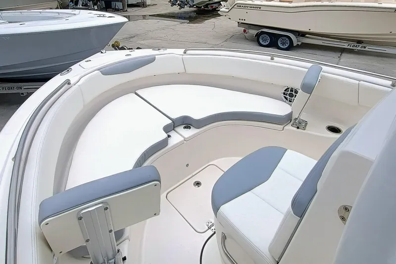 Slide: The Image of 2023 Robalo R222 Center Console boat interior with cushioned seating and storage. - 7