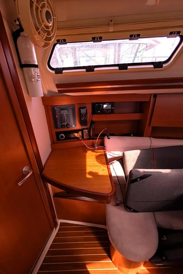 Slide: The Image of 2014 Hanse 325 yacht interior with navigation station and seating area. - 16