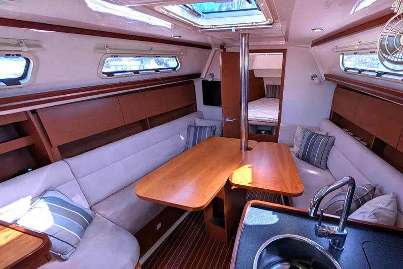 Slide: The Image of Interior of 2014 Hanse 325 sailboat with cozy seating and wooden table. - 22
