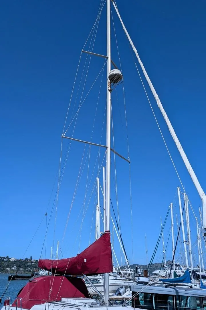 Slide: The Image of 2014 Hanse 325 sailboat with red cover docked under clear blue sky. - 3