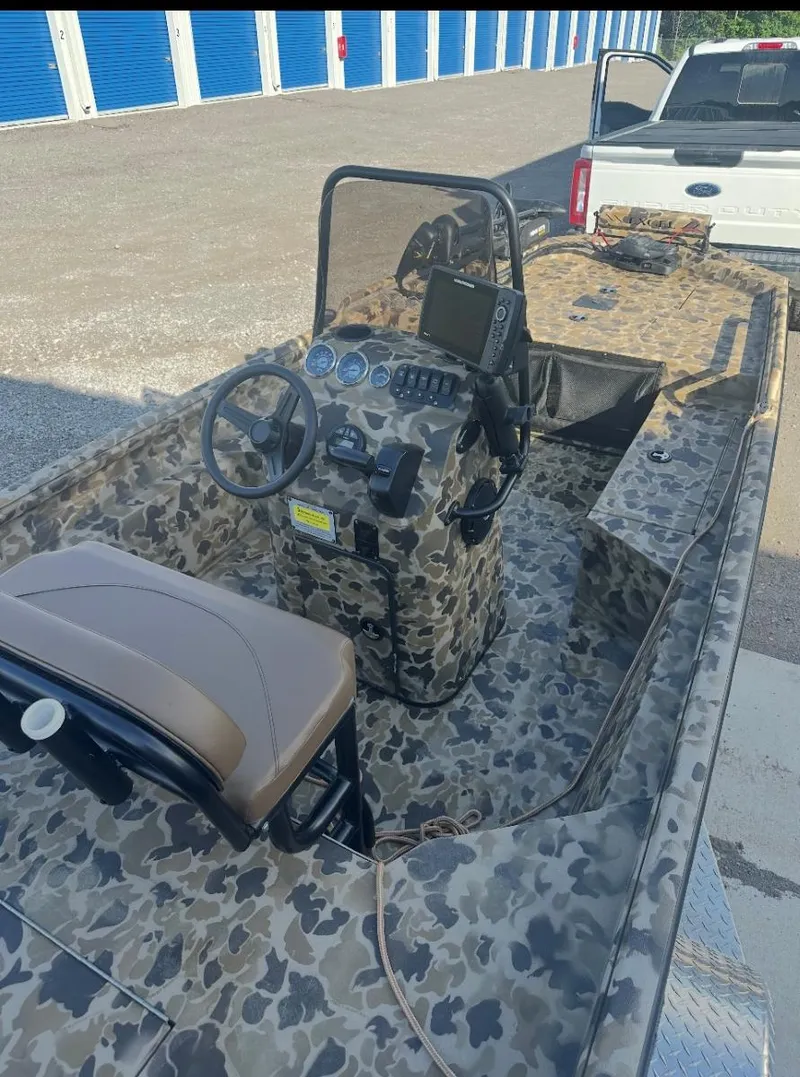 Slide: The Image of 2025 Excel 1860 F4 Shallow Water Pro Console boat with camouflage design and modern controls. - 11