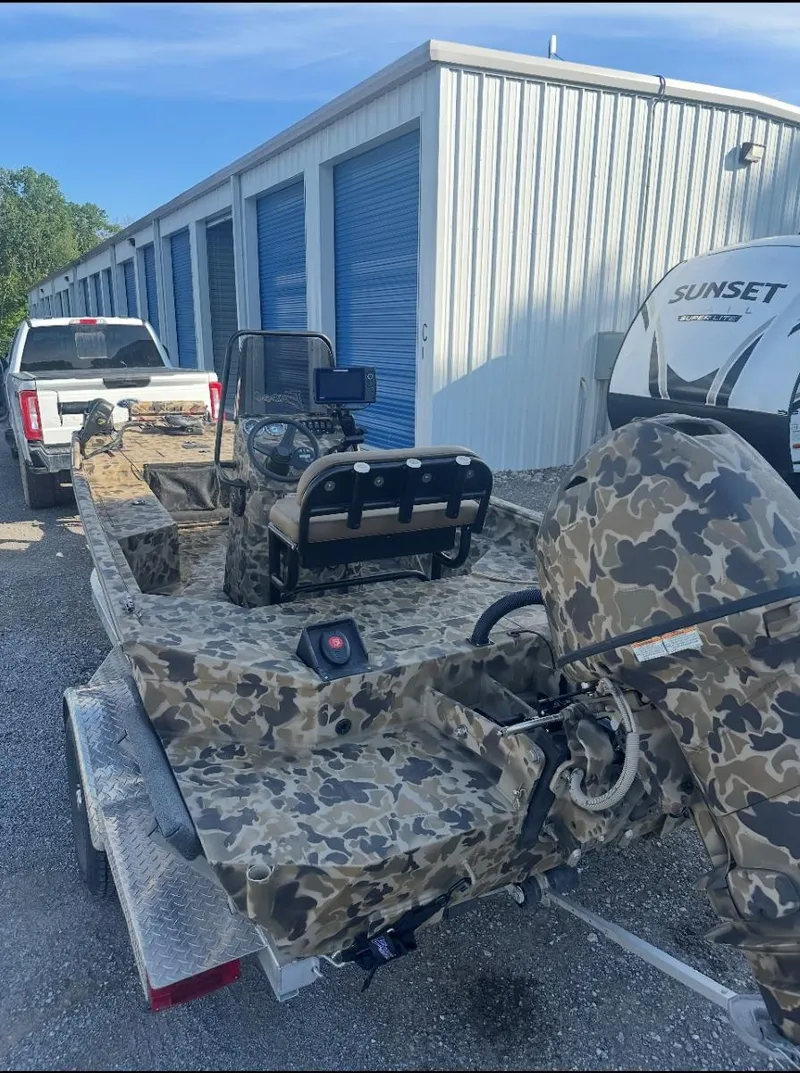 Slide: The Image of 2025 Excel 1860 F4 Shallow Water Pro Console boat with camouflage design on trailer. - 13