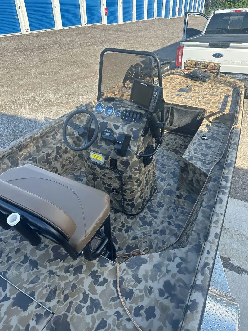 Slide: The Image of 2025 Excel 1860 F4 Shallow Water Pro Console boat with camouflage design and modern controls. - 3