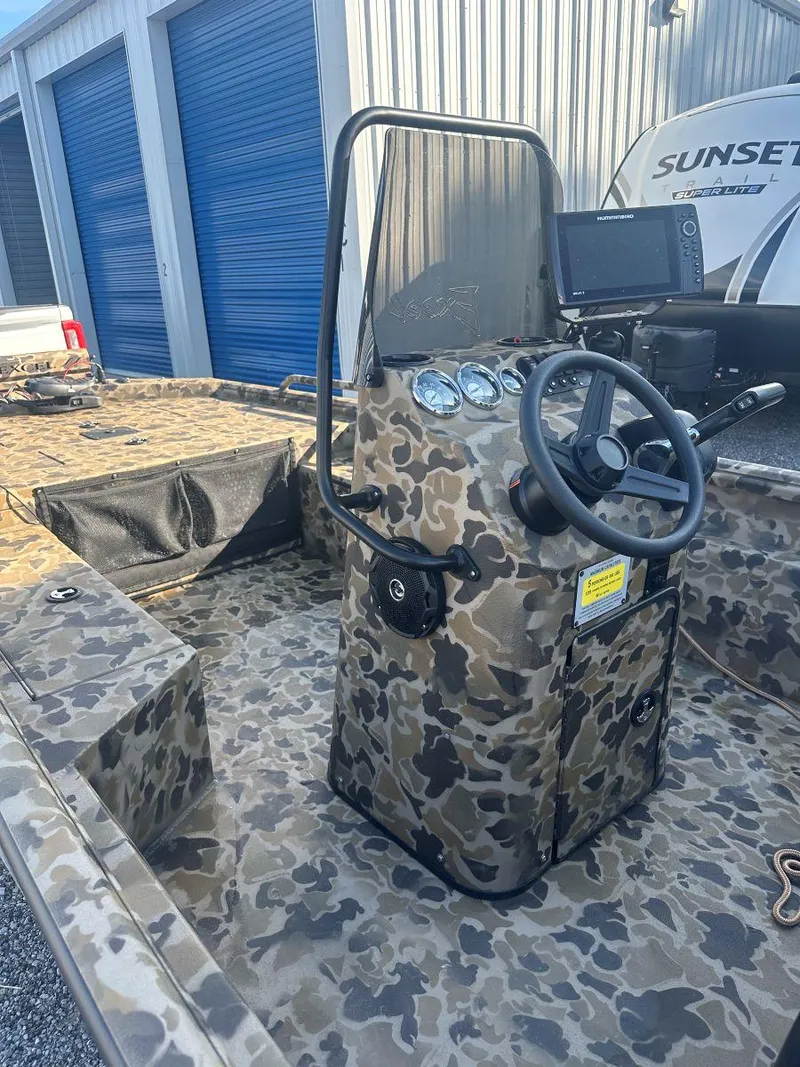 Slide: The Image of 2025 Excel 1860 F4 Shallow Water Pro Console boat with camouflage design in storage area. - 5