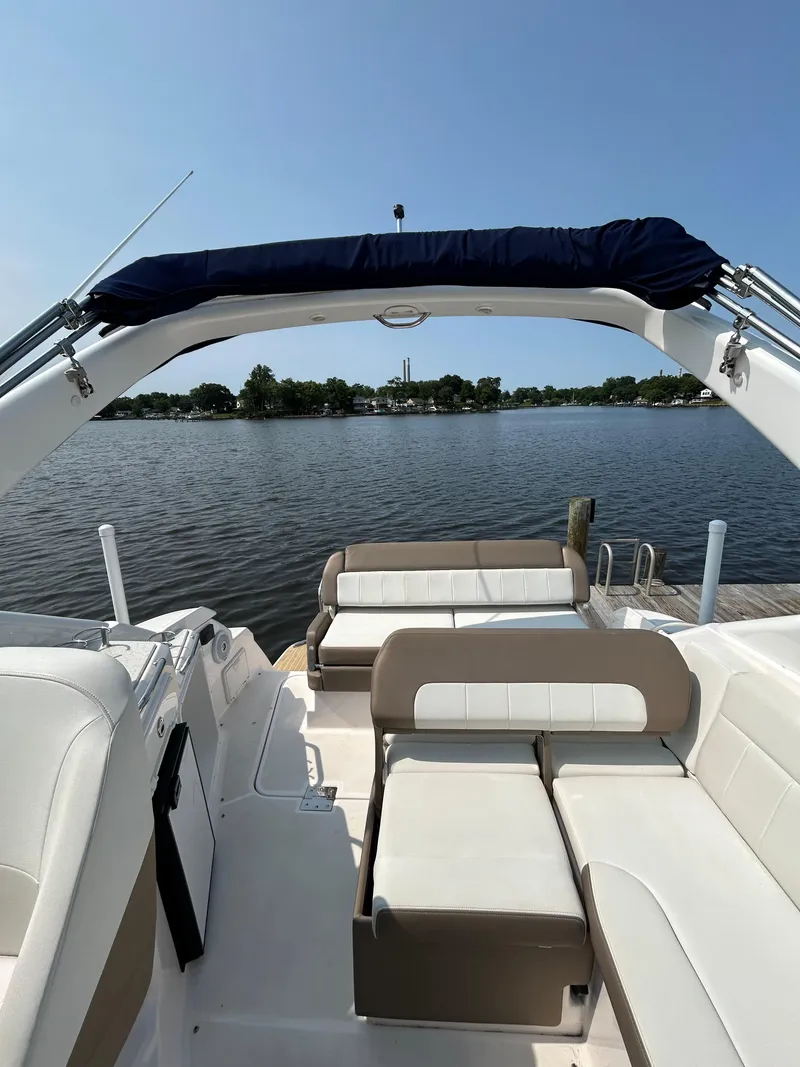 Slide: The Image of 2017 Regal 30 Express boat with white seating, docked on a calm lake. - 2