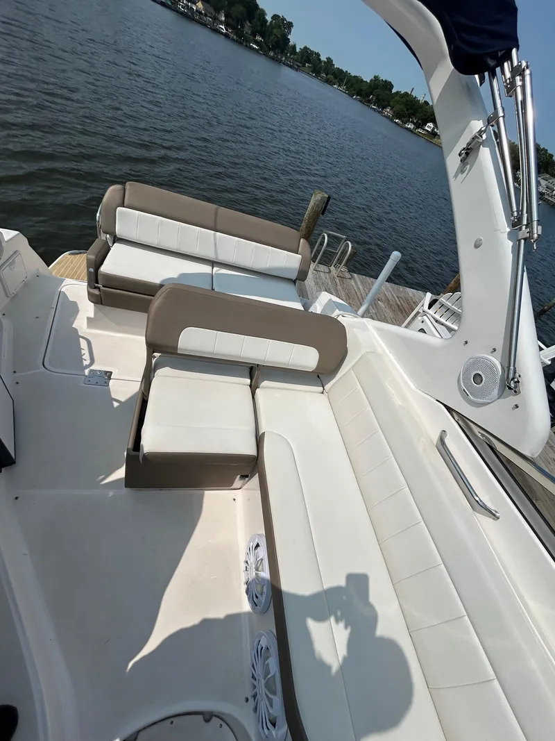 Slide: The Image of 2017 Regal 30 Express boat interior with beige seating, docked by a lake. - 3