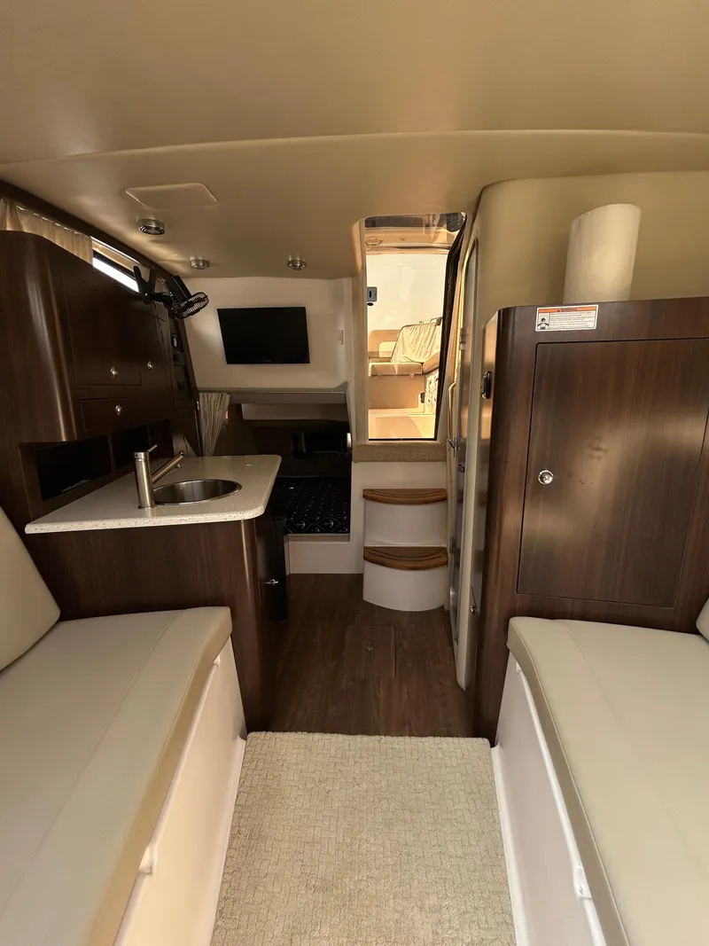 Slide: The Image of Interior of 2017 Regal 30 Express boat with seating, kitchenette, and stairs. - 7