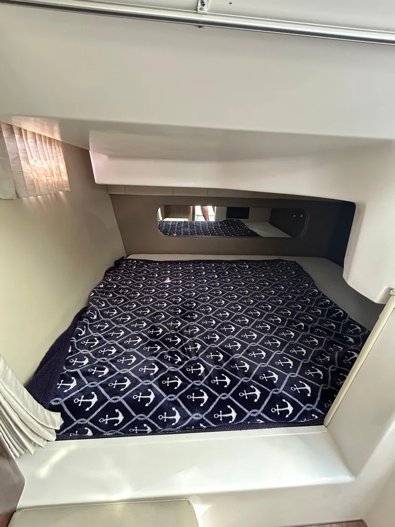 Slide: The Image of 2017 Regal 30 Express cabin interior with anchor-patterned bedding. - 9